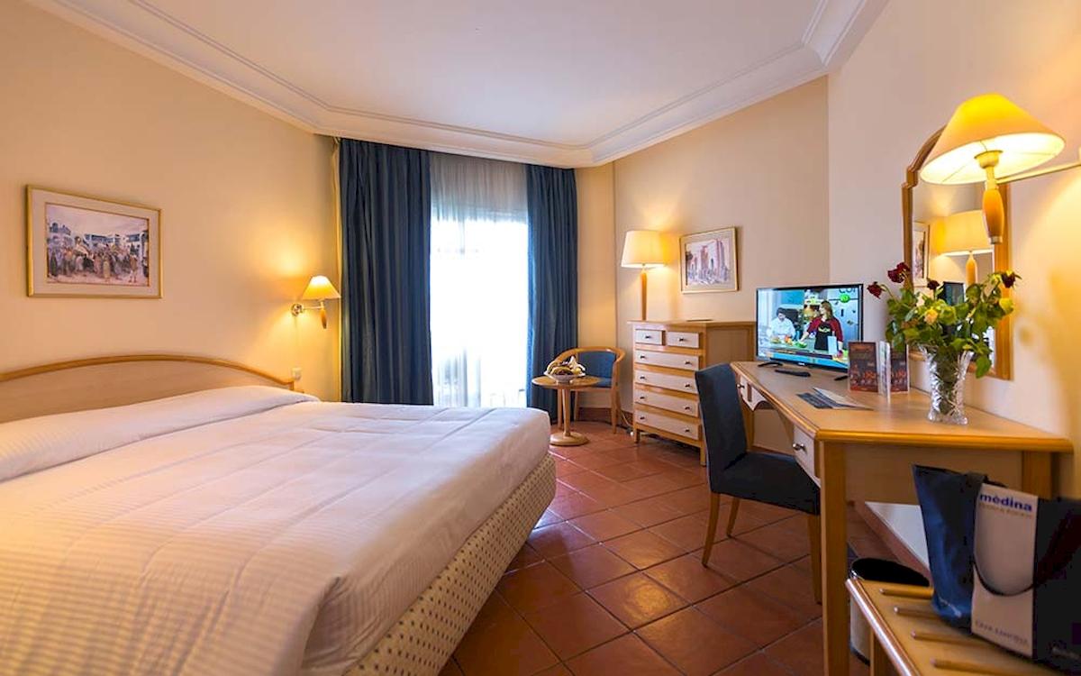 Hotelzimmer im Medina Belisaire & Thalasso mit Bett, Schreibtisch und Fernseher.