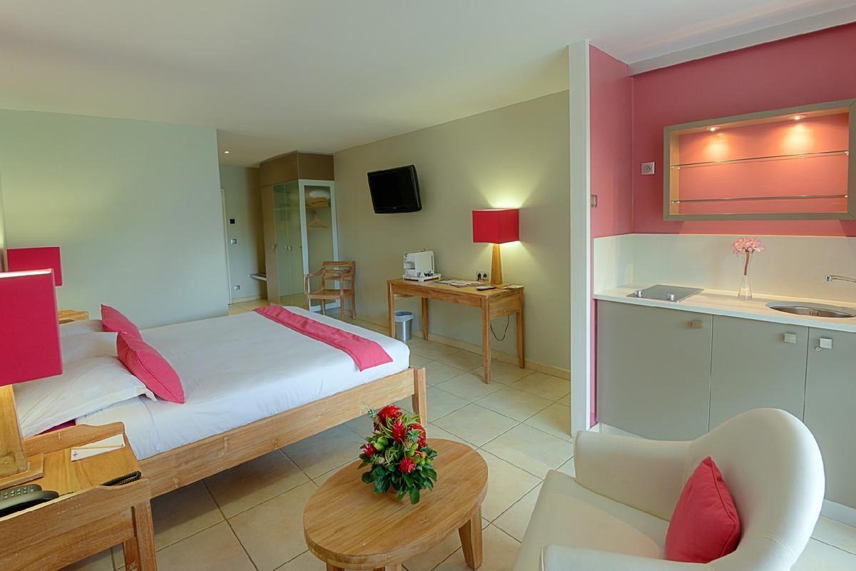 Zimmer im La Pagerie Tropical Garden Hotel mit Bett, Schreibtisch, Stuhl und Deko.