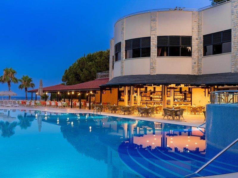 Abendansicht des Swimmingpools und des Restaurants des Melas Holiday Village.