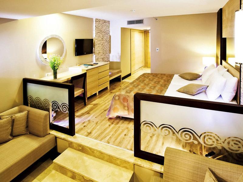 Suite-Zimmer im Melas Holiday Village mit Bett, Schreibtisch und Sofa