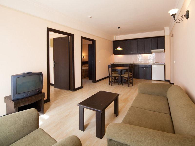 Wohnbereich im Melas Holiday Village mit Sofa, Tisch und Fernseher