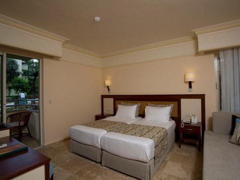 Doppelbett Zimmer im Melas Holiday Village mit Balkon und bequemem Sofa.