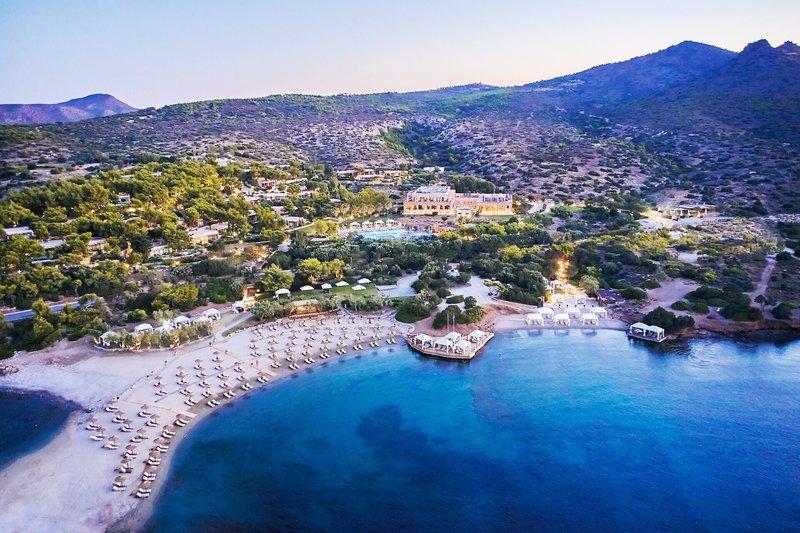 Luftaufnahme des Cape Sounio Grecotel Resorts am Strand mit vielen Liegen und einem Pool.