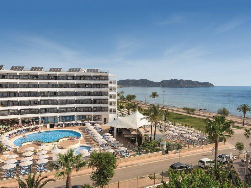 Außenansicht des Allsun Hotel Sumba mit Pool, Sonnenschirmen und Meer im Hintergrund.