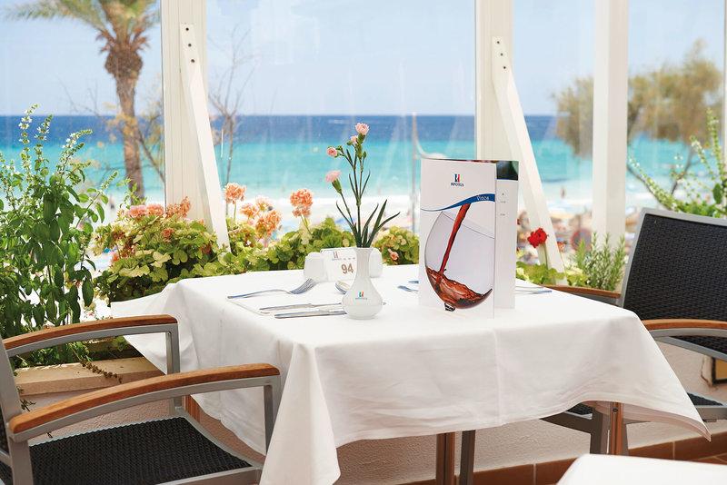 Tisch im Hipotels Don Juan mit Blick auf das Meer und Blumenarrangement