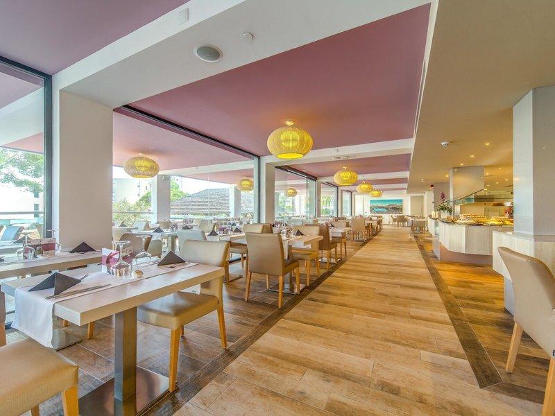 Innenansicht des Restaurants im Marins Playa Suites Hotel mit Tischen, Stühlen und Buffet.