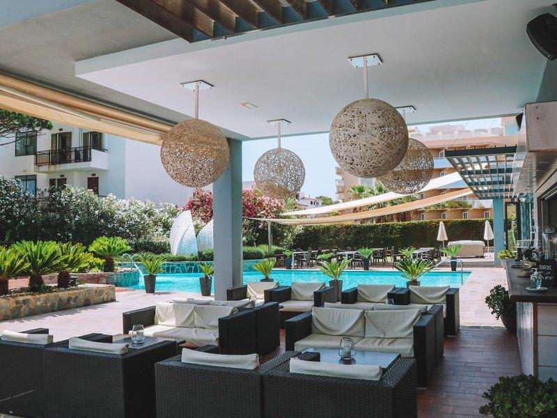 Loungebereich im Freien des Marins Playa Suites Hotels mit Sofas und einem Pool im Hintergrund.
