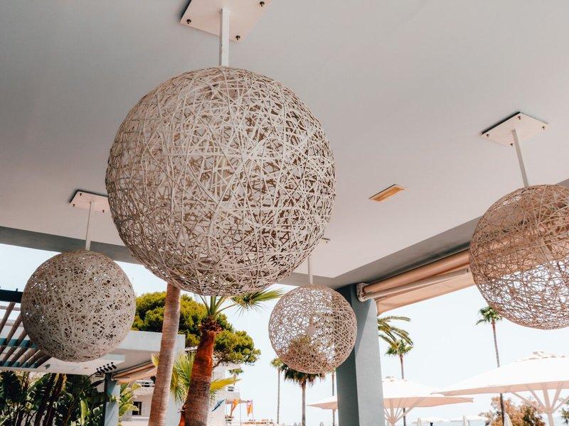 Vier runde Lampen hängen von der Decke im Freienbereich des Marins Playa Suites.