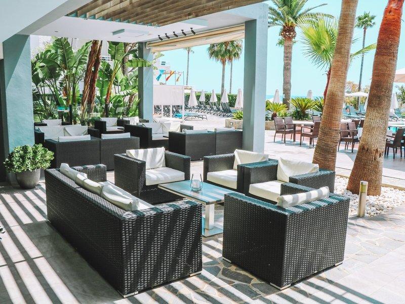 Außenbereich des Marins Playa Suites Hotels mit Möbeln und Palmen.