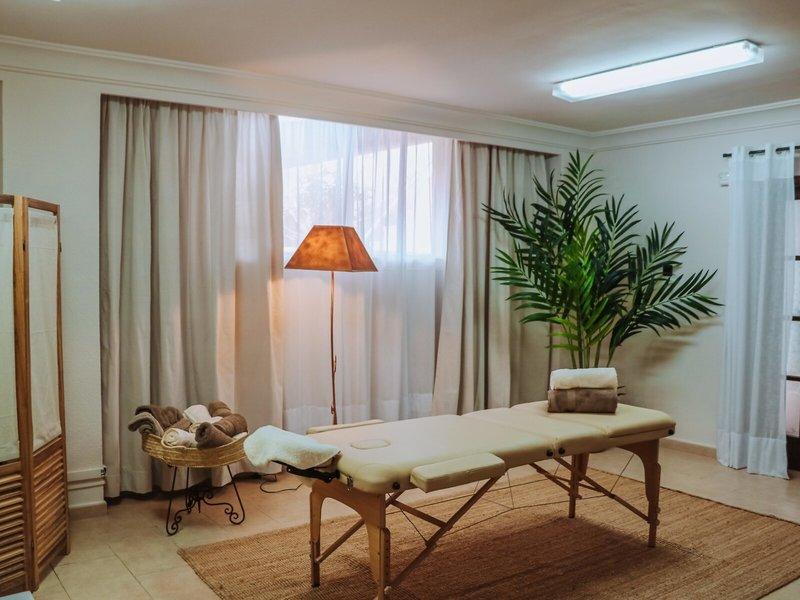 Massage-Behandlungsraum im Marins Playa Suites mit Therapiebett, Lampe und Pflanzen.