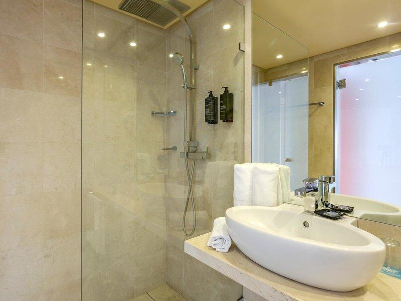 Badezimmer im Marins Playa Suites Hotel mit ebenerdiger Dusche und Waschbecken.