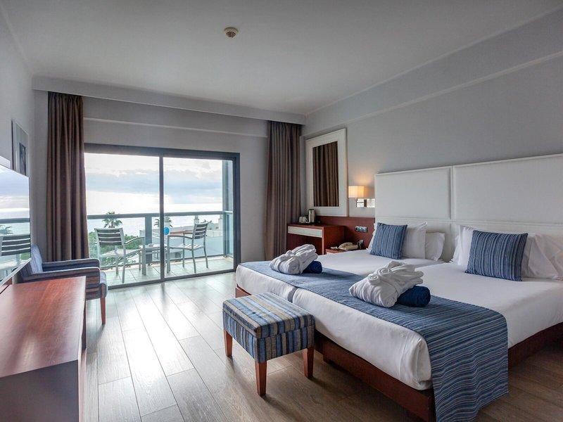 Zimmer im Marins Playa Suites Hotel mit Blick auf den Balkon und das Meer.