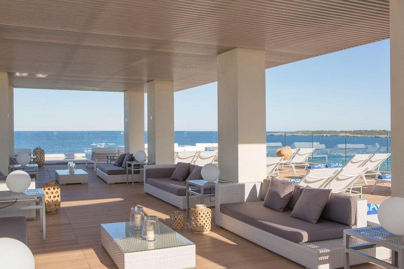 Außenbereich des Sabina & Suites Hotels mit Blick auf das Meer und modernen Möbeln.