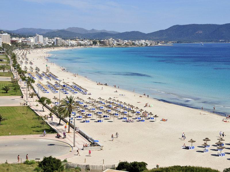 Ausblick auf den Strand neben dem R2 Veronica Beach Hotel mit vielen Sonnenschirmen und blauem Wasser.