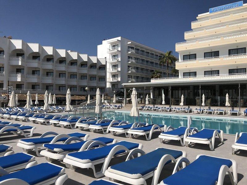 Poolbereich des R2 Veronica Beach Hotels mit vielen Liegestühlen und Sonnenschirmen.