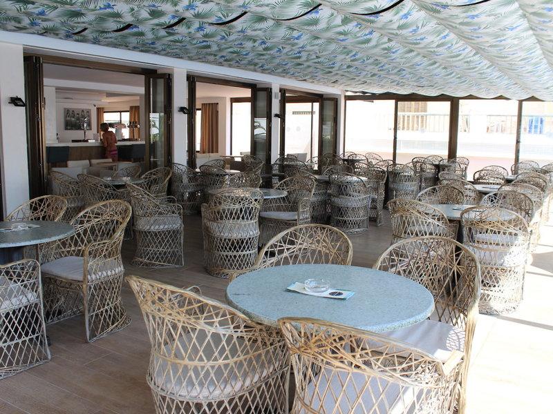 Innenbereich des R2 Veronica Strand Hotel mit vielen Tischen und Stühlen.