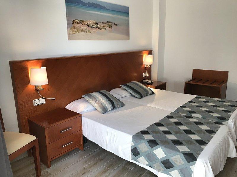 Hotelzimmer im R2 Veronica Beach Hotel mit zwei Betten, Nachttischen, Lampen und einem Gemälde an der Wand.