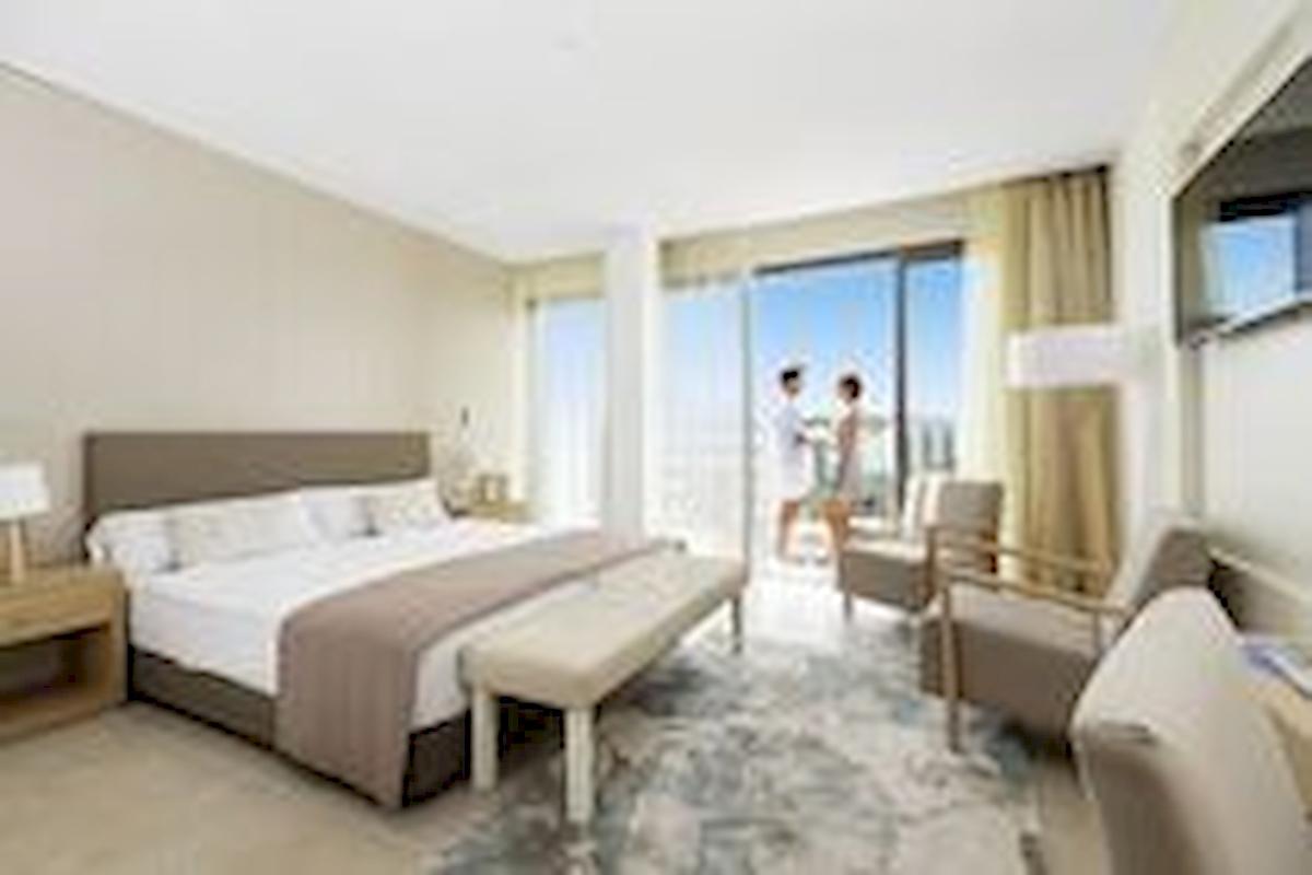 Schlafzimmer im Allsun Hotel Borneo mit großem Bett, Stühle, und Fenster mit Stadtblick.
