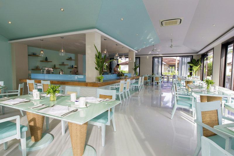 Innenansicht des Restaurants im TIA Wellness Resort mit blauen und weißen Möbeln.