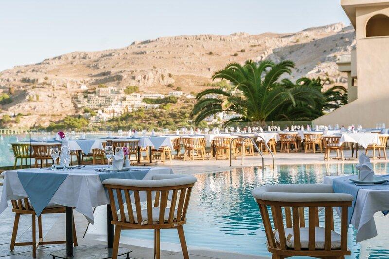Außen-Essbereich am Pool des Lindos Royal Resorts mit Blick auf die Berge