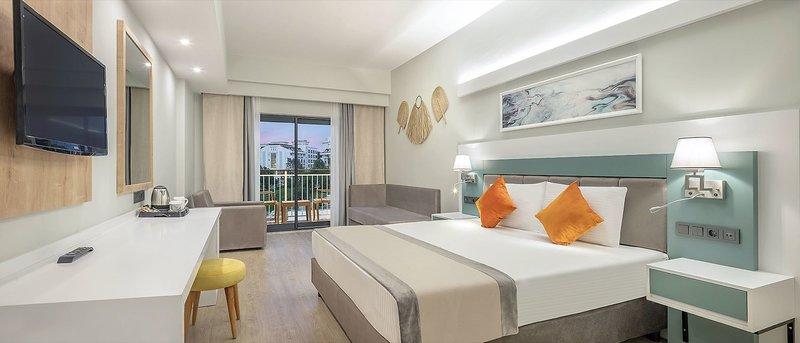 Ein modernes Hotelzimmer von Arcanus Hotels Trendline Side mit einem Bett, Fernseher, Schreibtisch und Balkon.