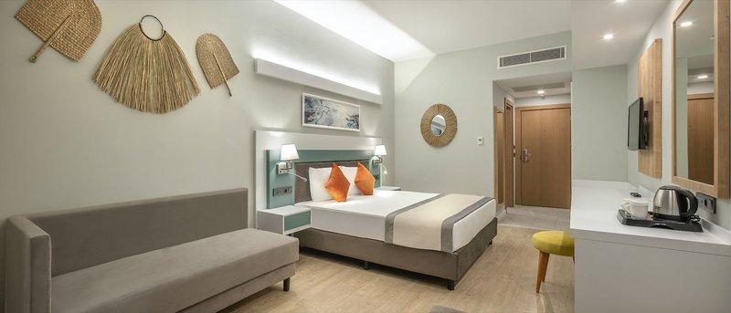 Ein modernes Hotelzimmer von Arcanus Hotels Trendline Side mit einem Bett, Sofa, Schreibtisch und Dekor.