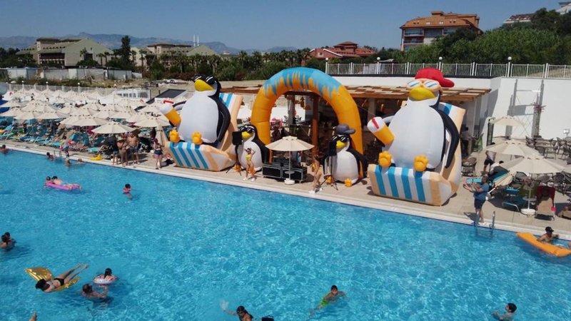 Schwimmbadbereich des Arcanus Hotels Trendline Side mit großen Pinguinfiguren und vielen Gästen