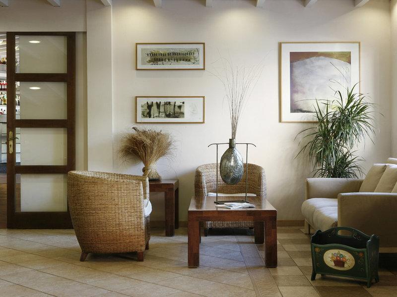 Lobby des Voramar Formentera Hotels mit Möbeln und Kunstwerken an der Wand.