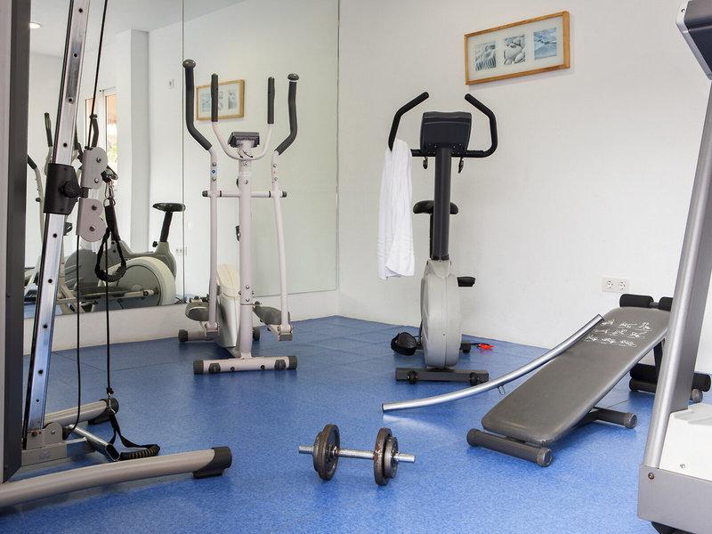 Fitnessraum im Hotel Voramar Formentera mit verschiedenen Trainingsgeräten und blauem Boden.