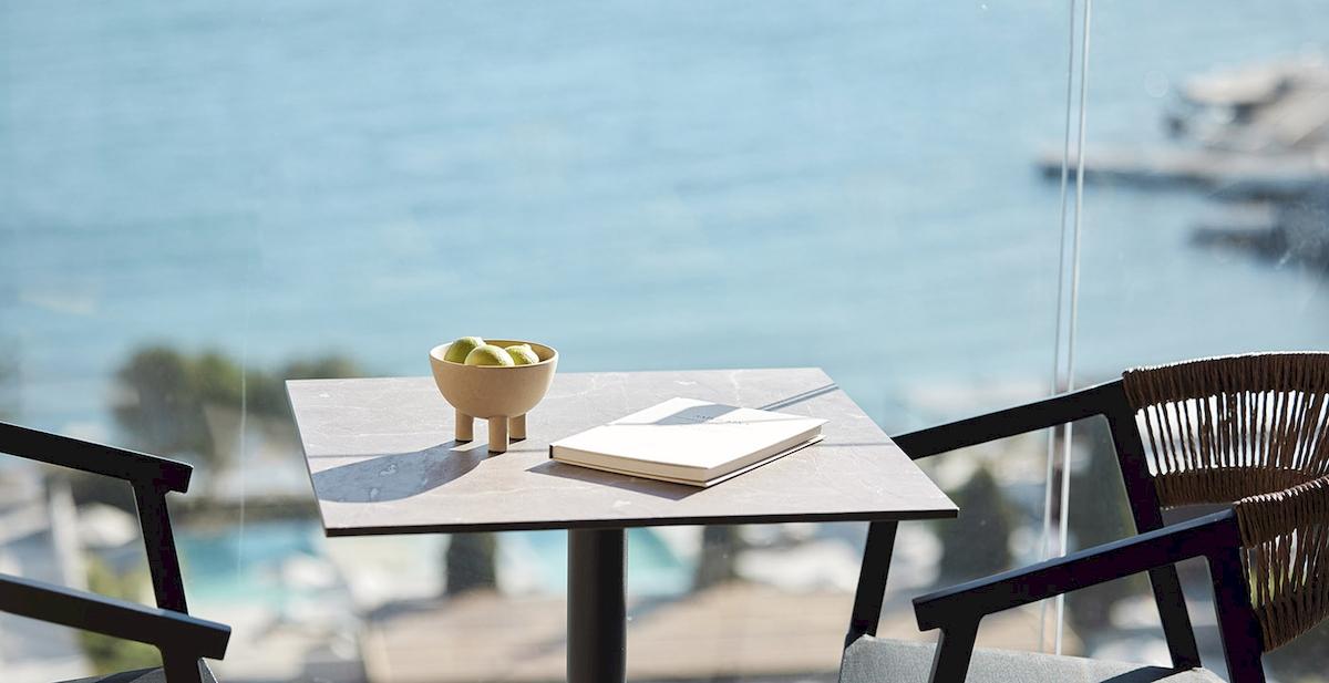 Tisch mit Buch und Obst am Meer im Helea Lifestyle Beach Resort