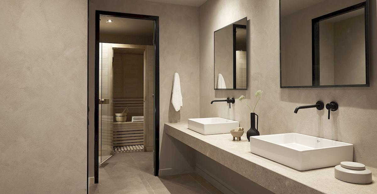 Badezimmer im Helea Lifestyle Beach Resort mit zwei Waschbecken, Spiegeln und einer Sauna.