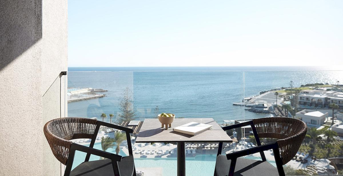 Blick aus Balkon des Helea Lifestyle Beach Resort auf das Meer und einen Pool.