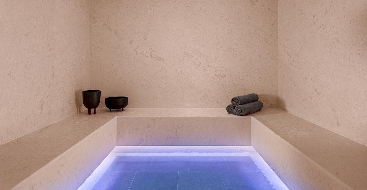 Dampfbad im Helea Lifestyle Beach Resort mit blau beleuchtetem Boden und zwei schwarzen Bechern