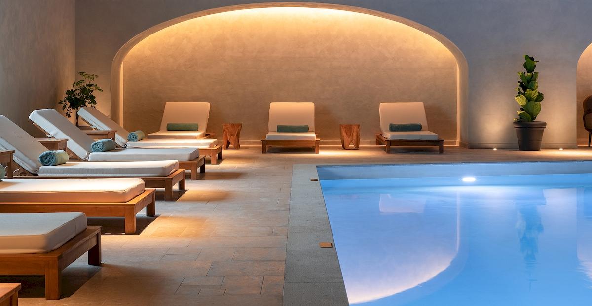Loungebereich im Helea Lifestyle Beach Resort mit weißen Liegen und einem Pool.