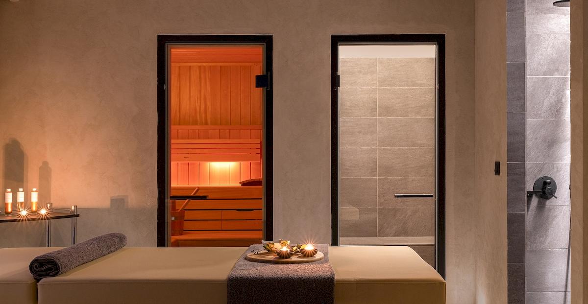 Saunaraum im Helea Lifestyle Beach Resort mit offenen Türen und Kerzenlicht.
