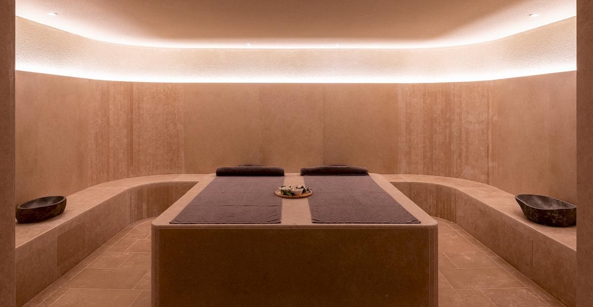 Massageraum im Helea Lifestyle Beach Resort mit zwei Liegen und dekorativen Elementen.