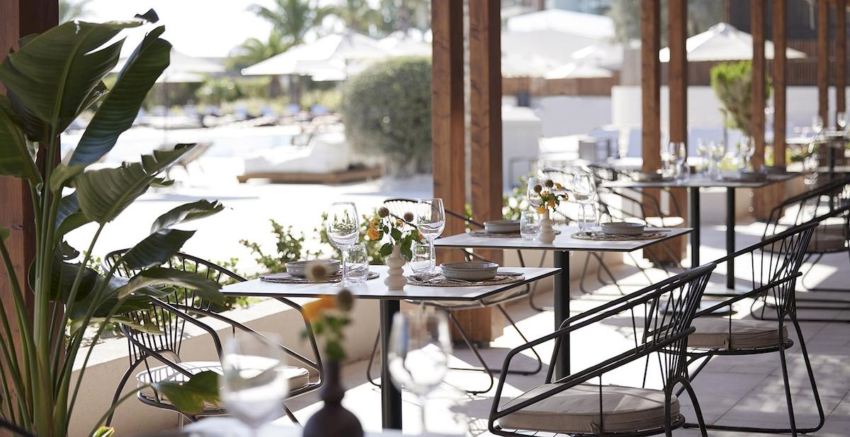 Außenbereich des Helea Lifestyle Beach Resorts mit Tisch und Stühlen im Freien.