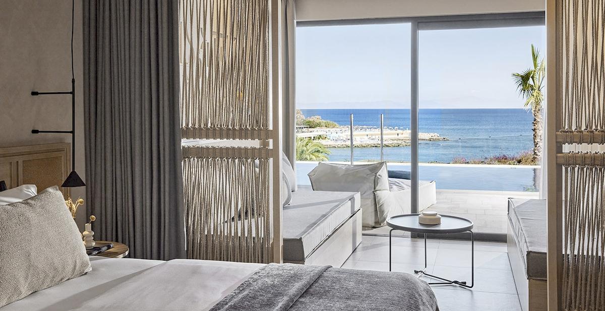 Zimmer im Helea Lifestyle Beach Resort mit Meerblick, inklusive Bett, Tisch, und Aussicht auf den Ozean.