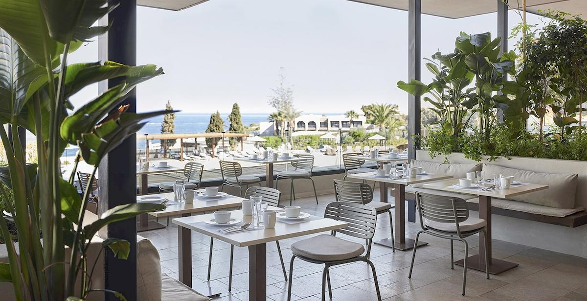 Innenansicht des Restaurants im Helea Lifestyle Beach Resort mit Blick auf das Meer und den Garten.