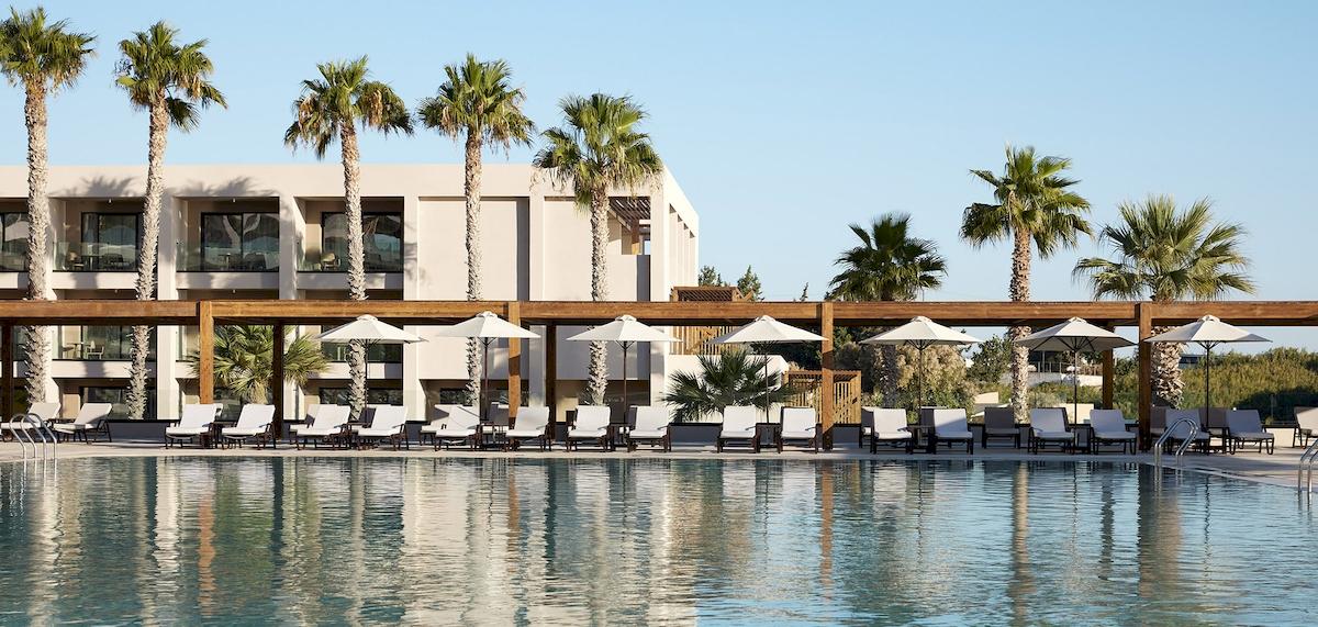 Pool-Lounge-Bereich des Helea Lifestyle Beach Resorts mit Sonnenliegen und Sonnenschirmen.