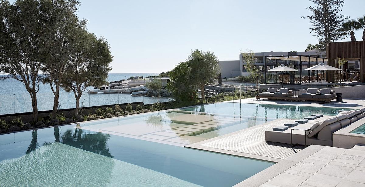 Außenpool des Helea Lifestyle Beach Resorts mit Blick auf das Meer und moderne Loungemöbel.