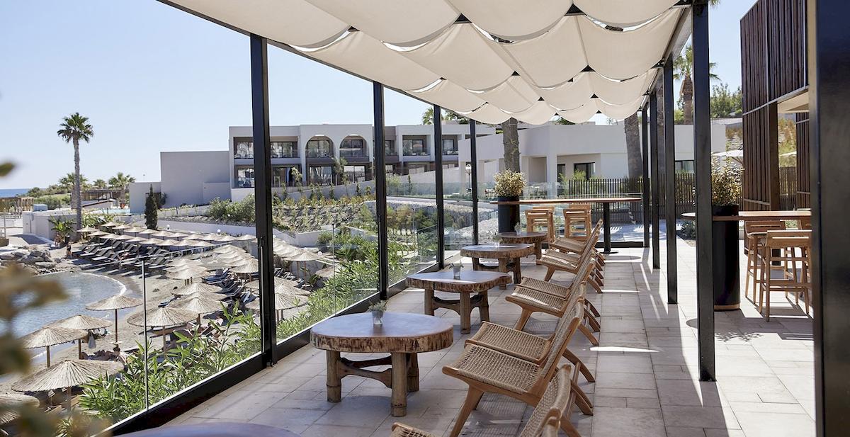 Terrasse im Helea Lifestyle Beach Resort mit Blick auf einen Pool und eine tropische Landschaft