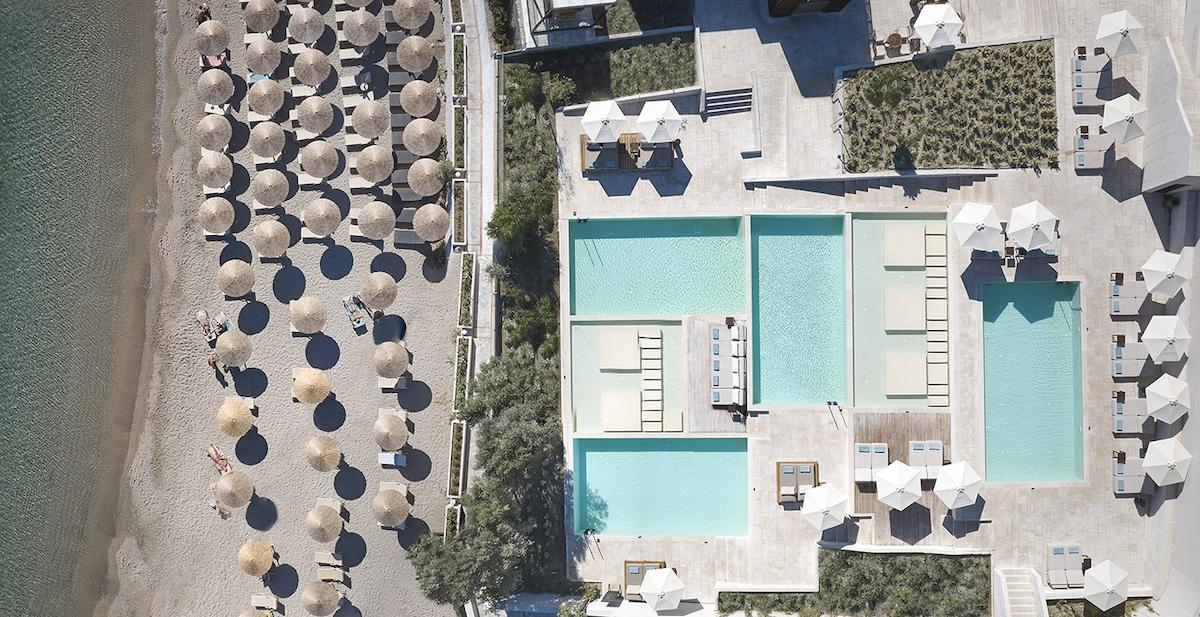 Luftaufnahme des Helea Lifestyle Beach Resorts mit Pools und Sonnenschirmen am Strand