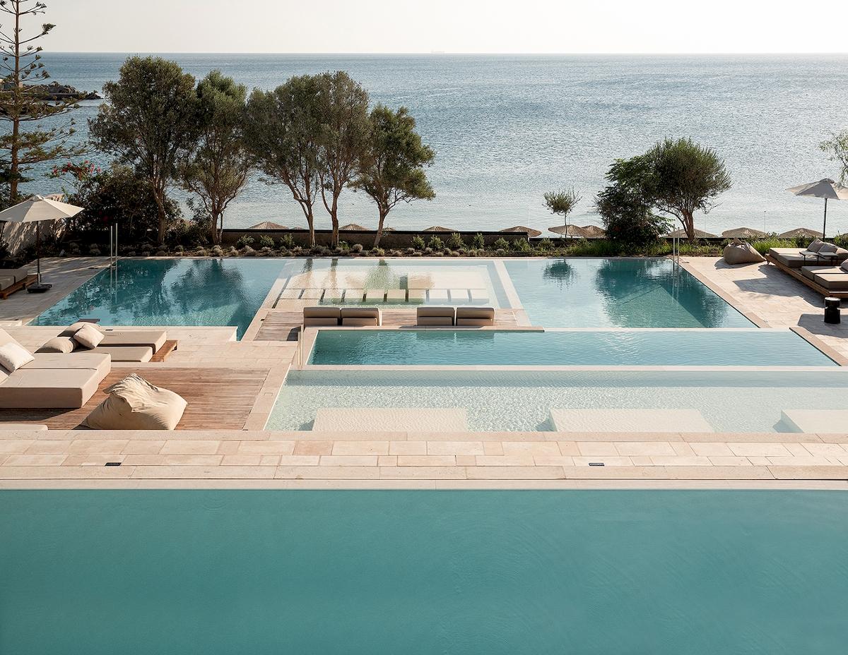 Außenpoolbereich des Helea Lifestyle Beach Resorts mit Blick auf das Meer und Liegestühlen