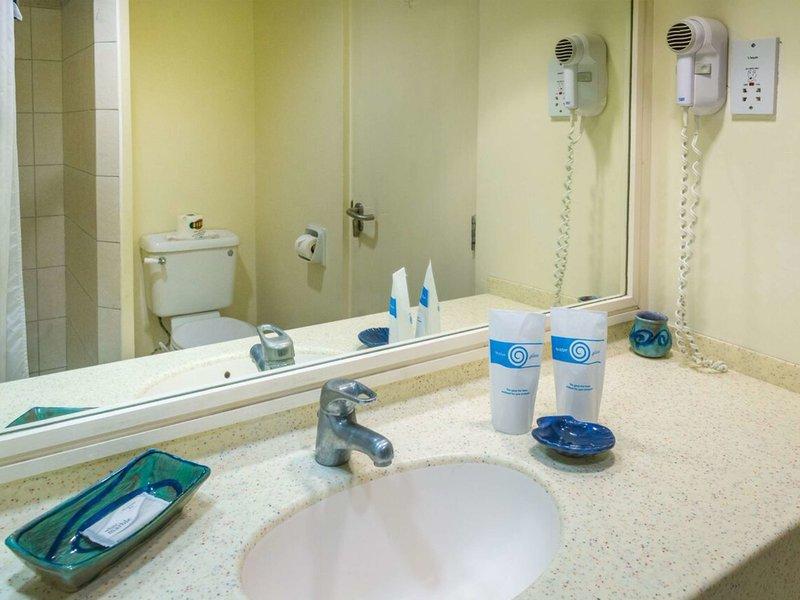 Badezimmer im Rostrevor Hotel mit Spiegel, Waschbecken und Toilette.