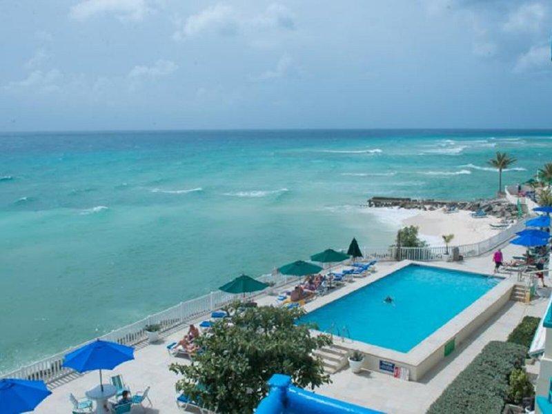 Ausblick des Rostrevor Hotels auf den Pool und das Meer, mit Sonnenliegen und Sonnenschirmen