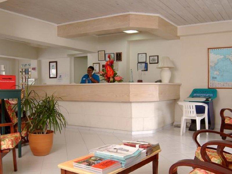Empfangsbereich des Rostrevor Hotels mit Rezeptionistin und Blumendekor.
