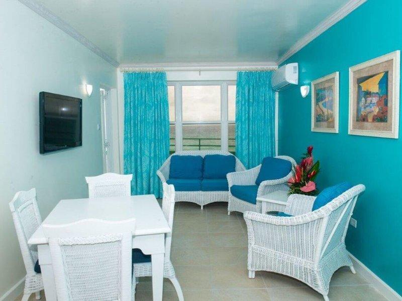 Wohnzimmer des Rostrevor Hotels mit blauen Wänden, weißen Möbeln und einem Ausblick auf das Meer.