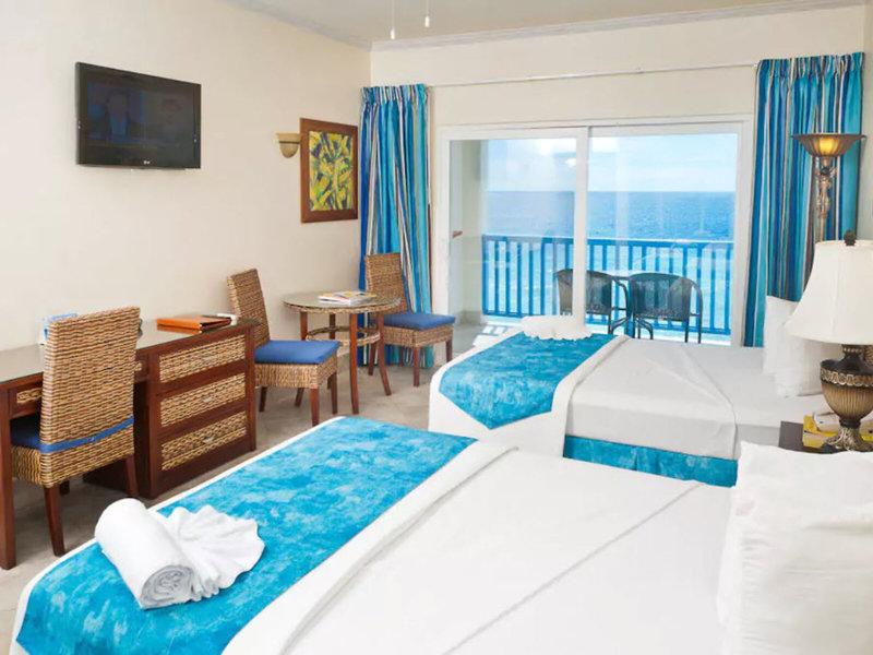 Doppelzimmer im Rostrevor Hotel mit Meerblick, zwei Betten, Schreibtisch und Balkon.