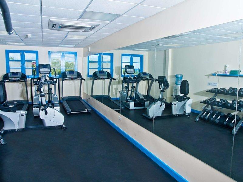 Fitnessbereich des Rostrevor Hotels mit Laufbändern, Spinrädern und Hanteln.